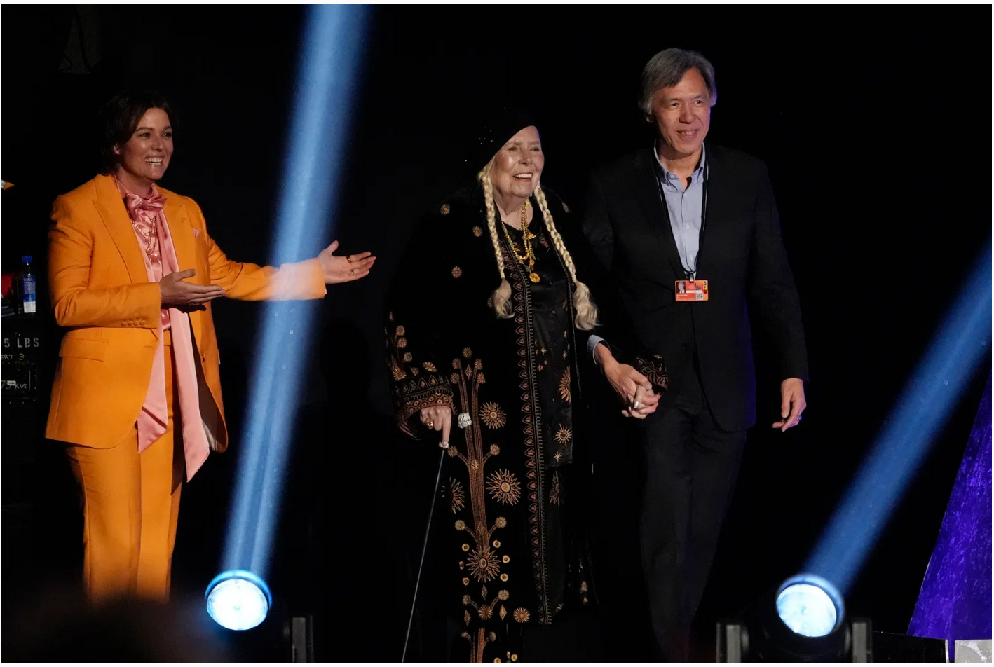 Brandi Carlile presents Joni Mitchell, center, as she walks on stage to accept the award for best folk album for “Joni Mitchell at Newport” during the 66th annual Grammy Awards on Feb. 4, 2024, in Los Angeles. (Chris Pizzello/AP)